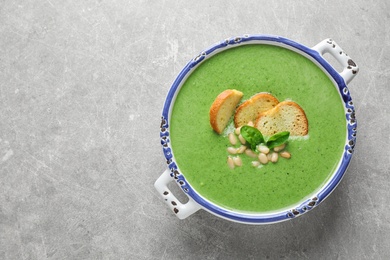 Photo of Bowl of healthy green soup with fresh spinach on light table, top view. Space for text