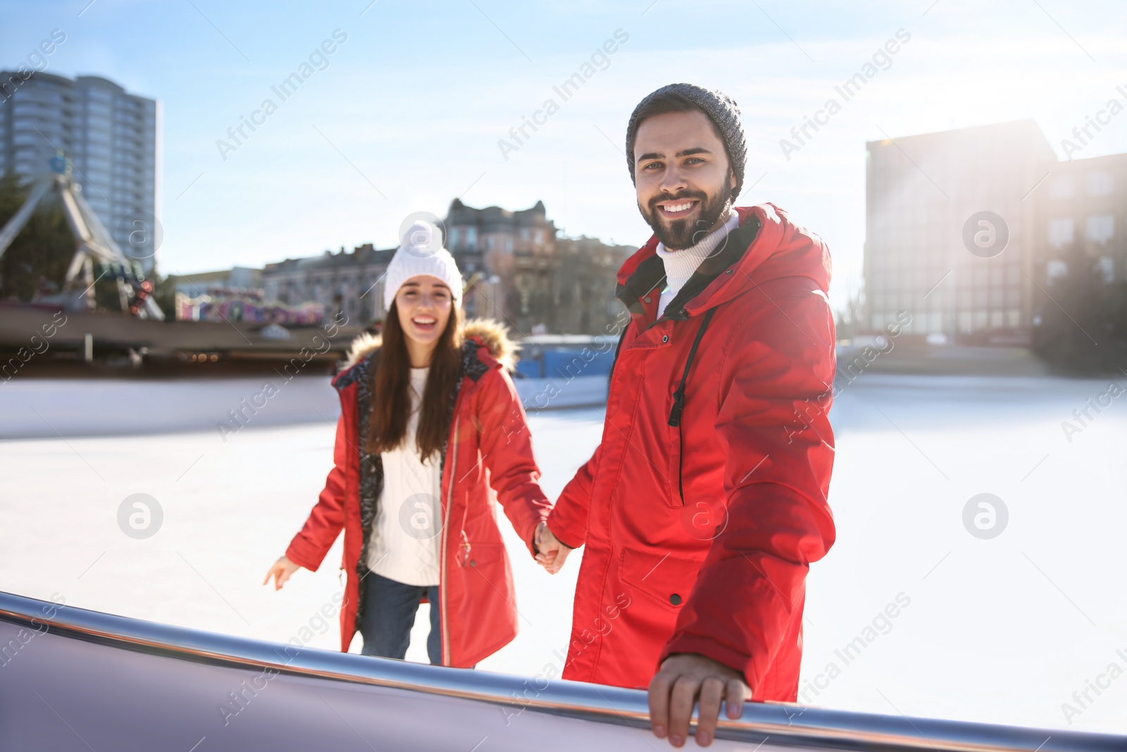 Image of Lovely couple spending time together at outdoor ice skating rink