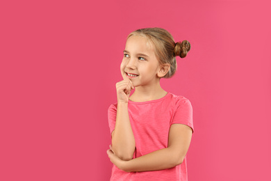 Photo of Cute little girl posing on pink background