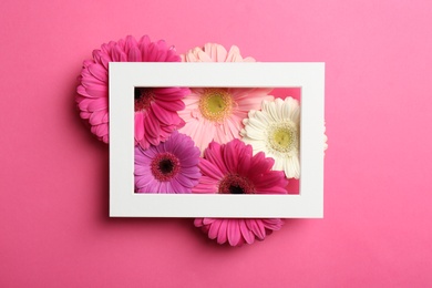 Photo of Flat lay composition with beautiful flowers and frame on color background