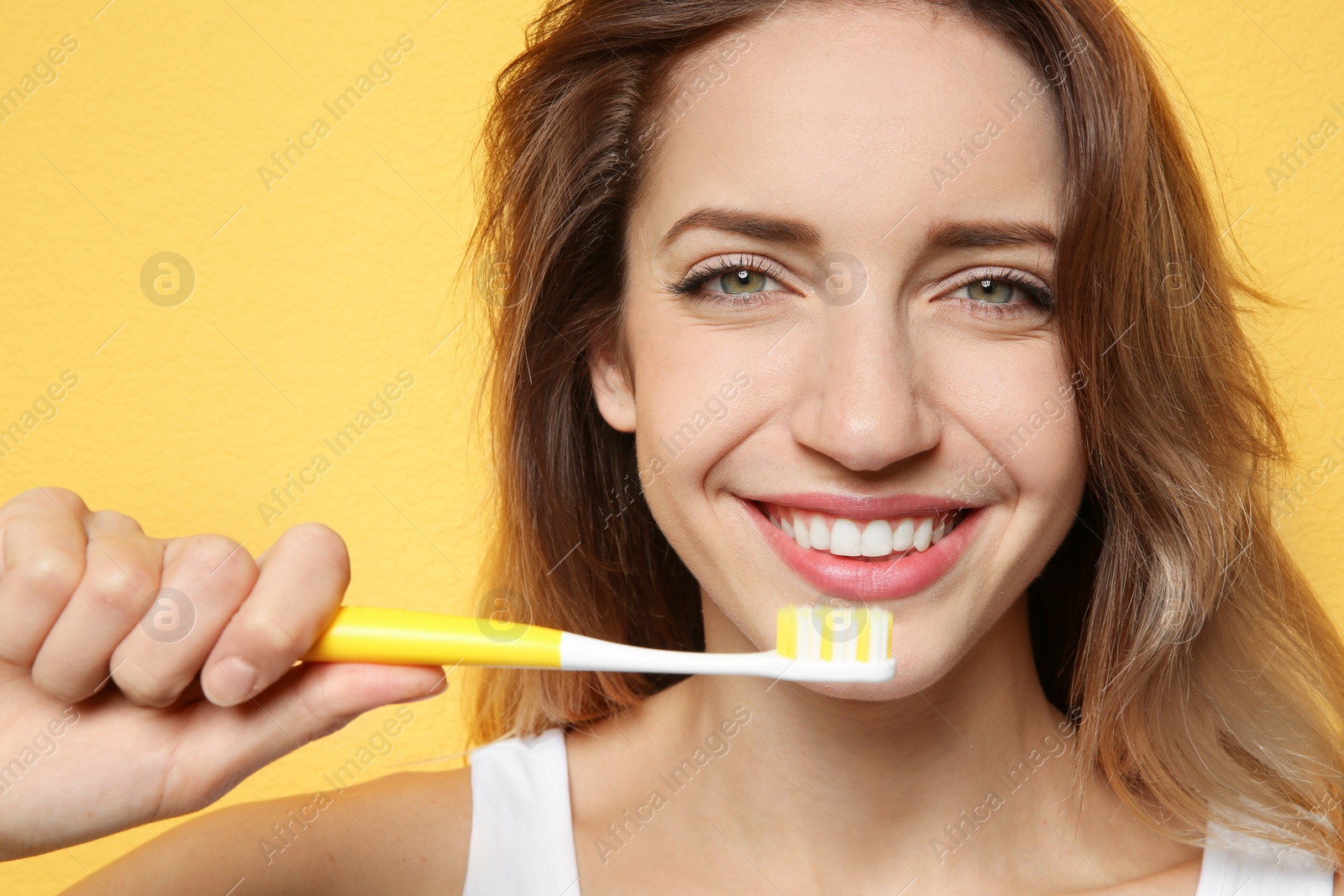 Photo of Portrait of young woman with toothbrush on color background