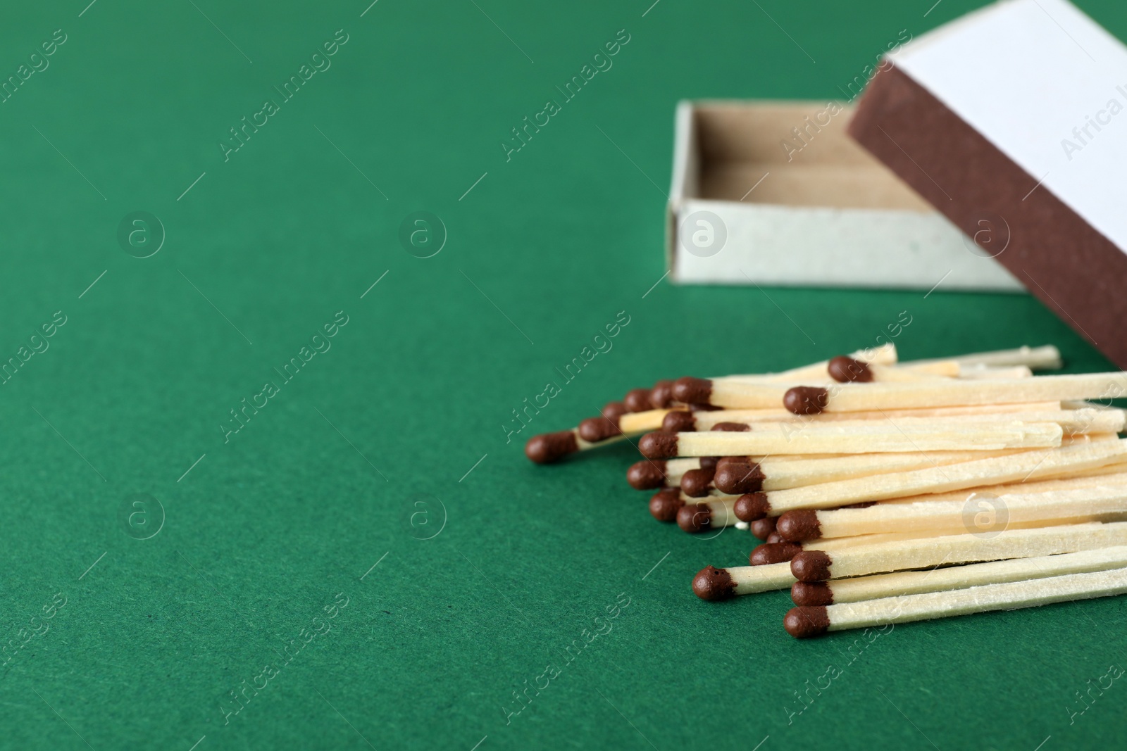 Photo of Open box and matches on color background, space for text