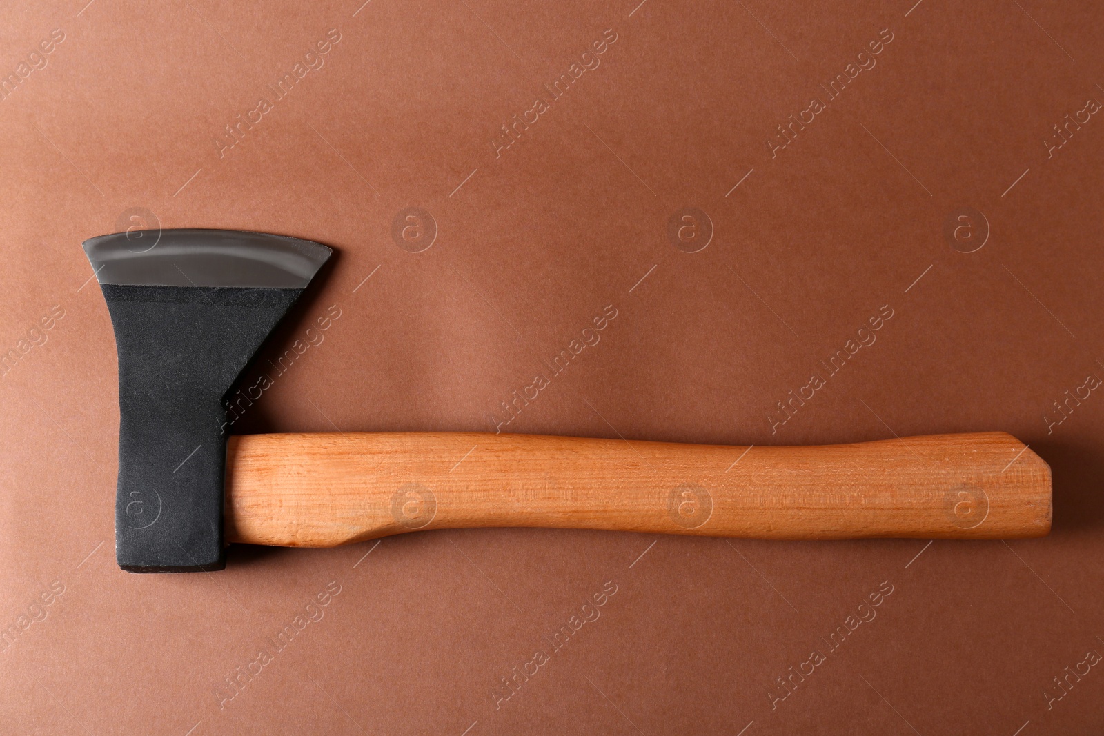 Photo of Ax with wooden handle on brown background, top view