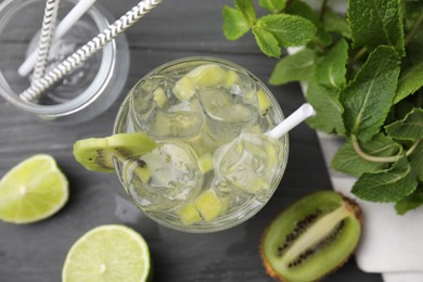 Photo of Glass of refreshing drink with kiwi and ingredients on gray table, flat lay