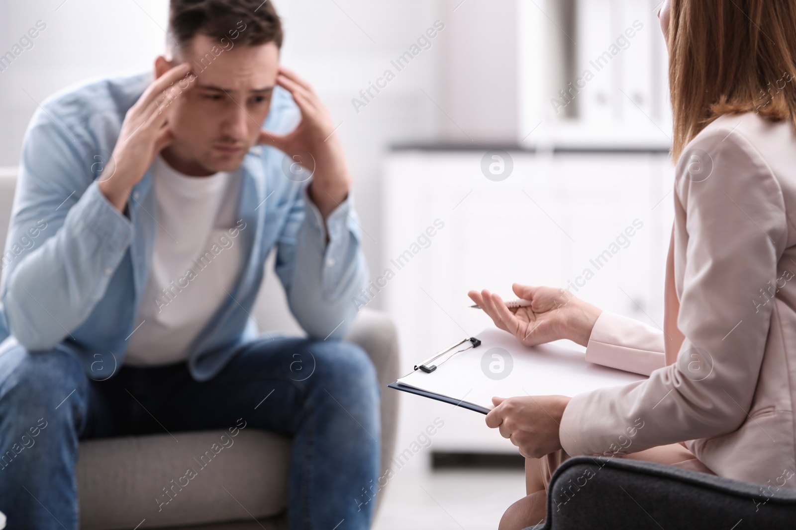 Photo of Psychotherapist working with young man in office