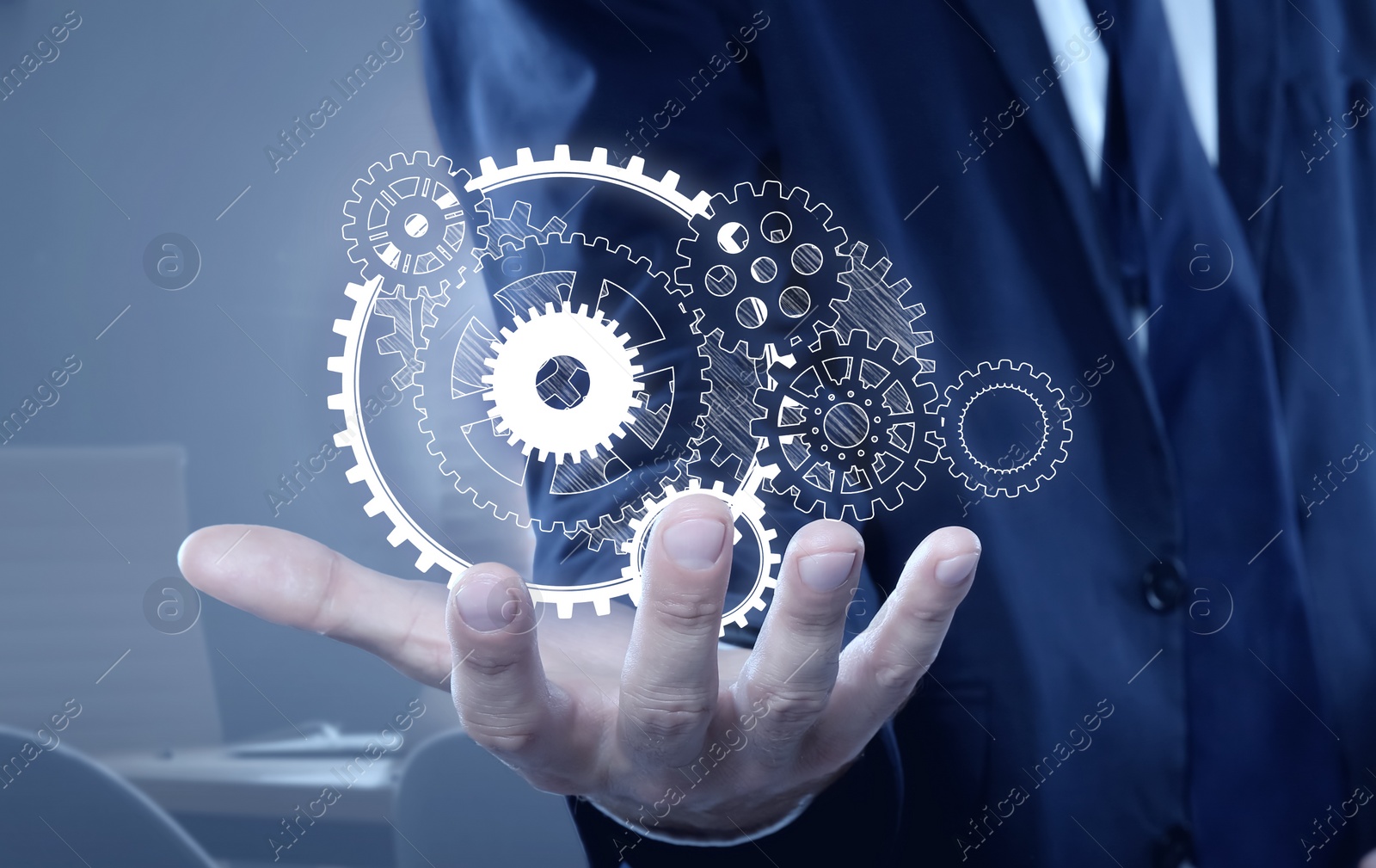 Image of Businessman demonstrating gear mechanism in office, closeup