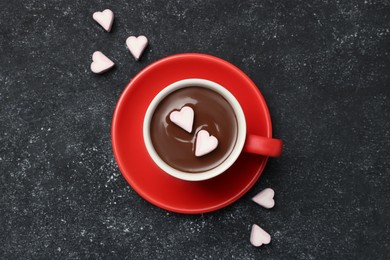 Photo of Cup of hot chocolate with heart shaped marshmallows on grey table, top view