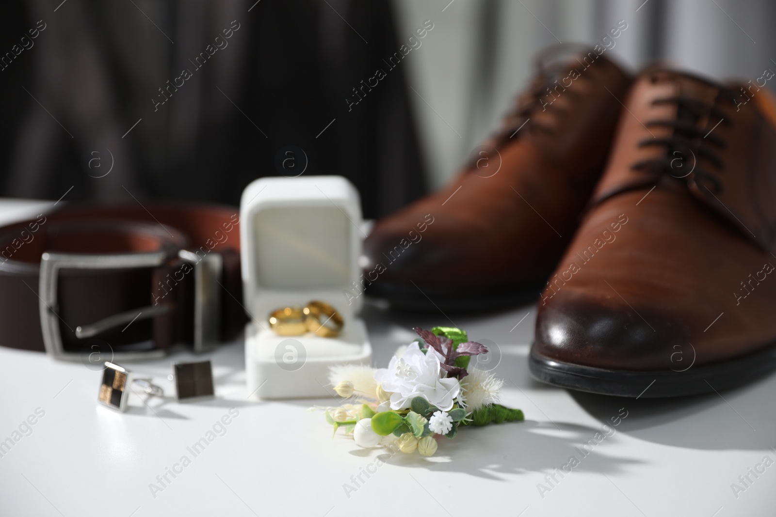Photo of Wedding stuff. Composition with stylish boutonniere on white surface, closeup