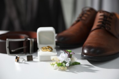 Wedding stuff. Composition with stylish boutonniere on white surface, closeup