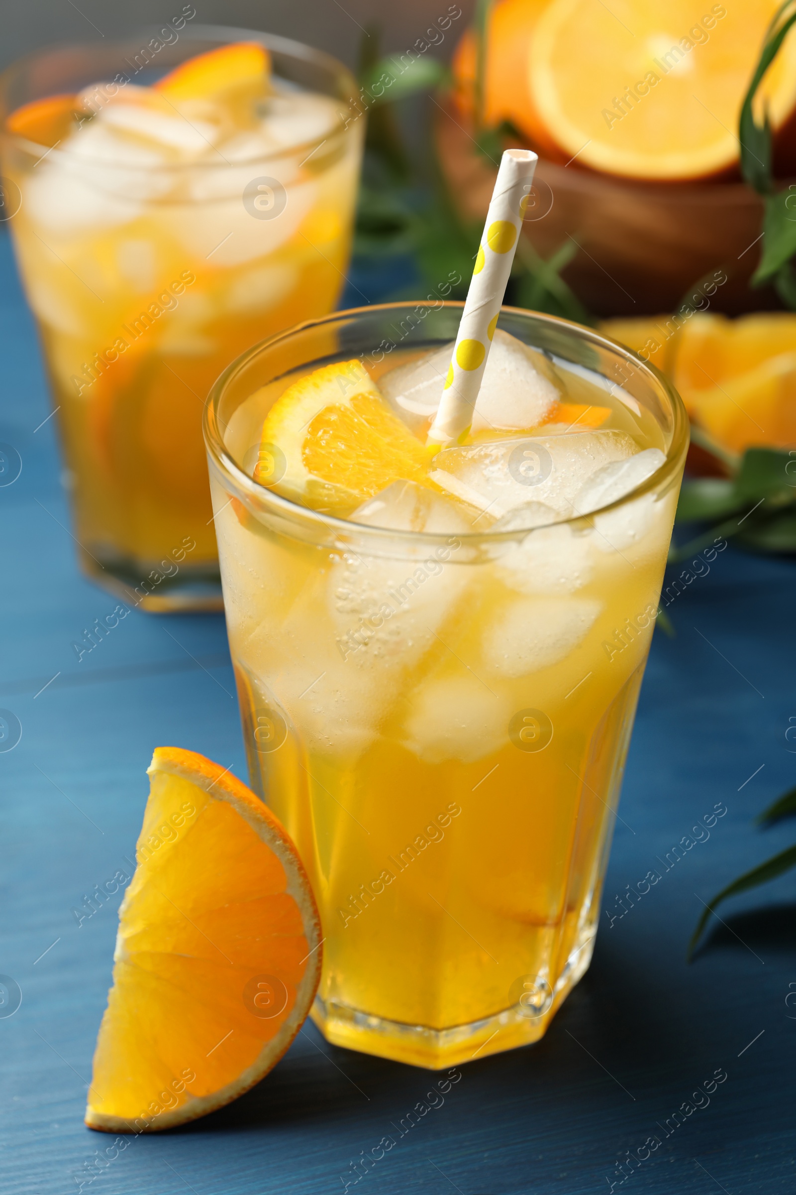 Photo of Delicious orange soda water on blue wooden table