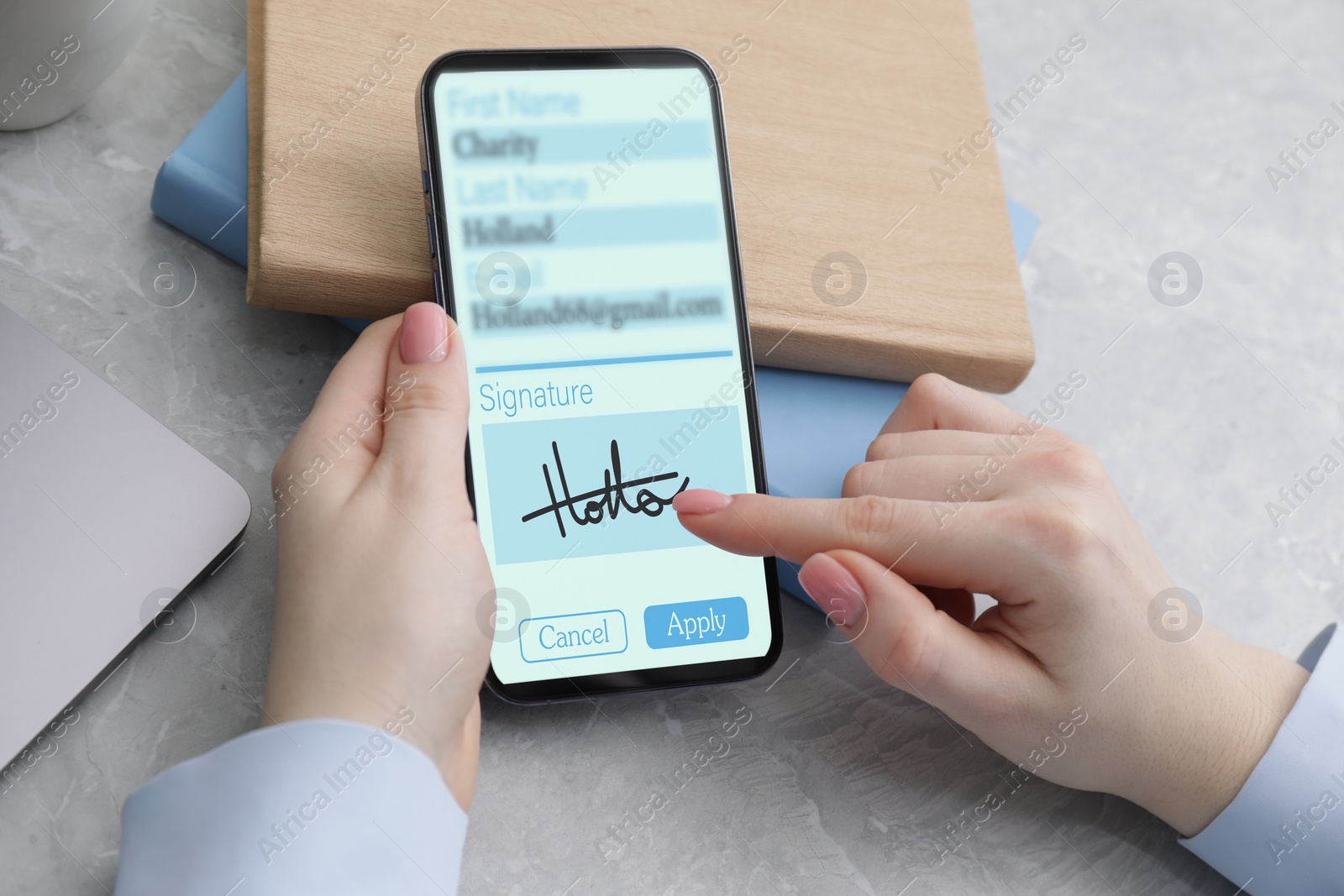 Image of Electronic signature. Woman using mobile phone at table, closeup