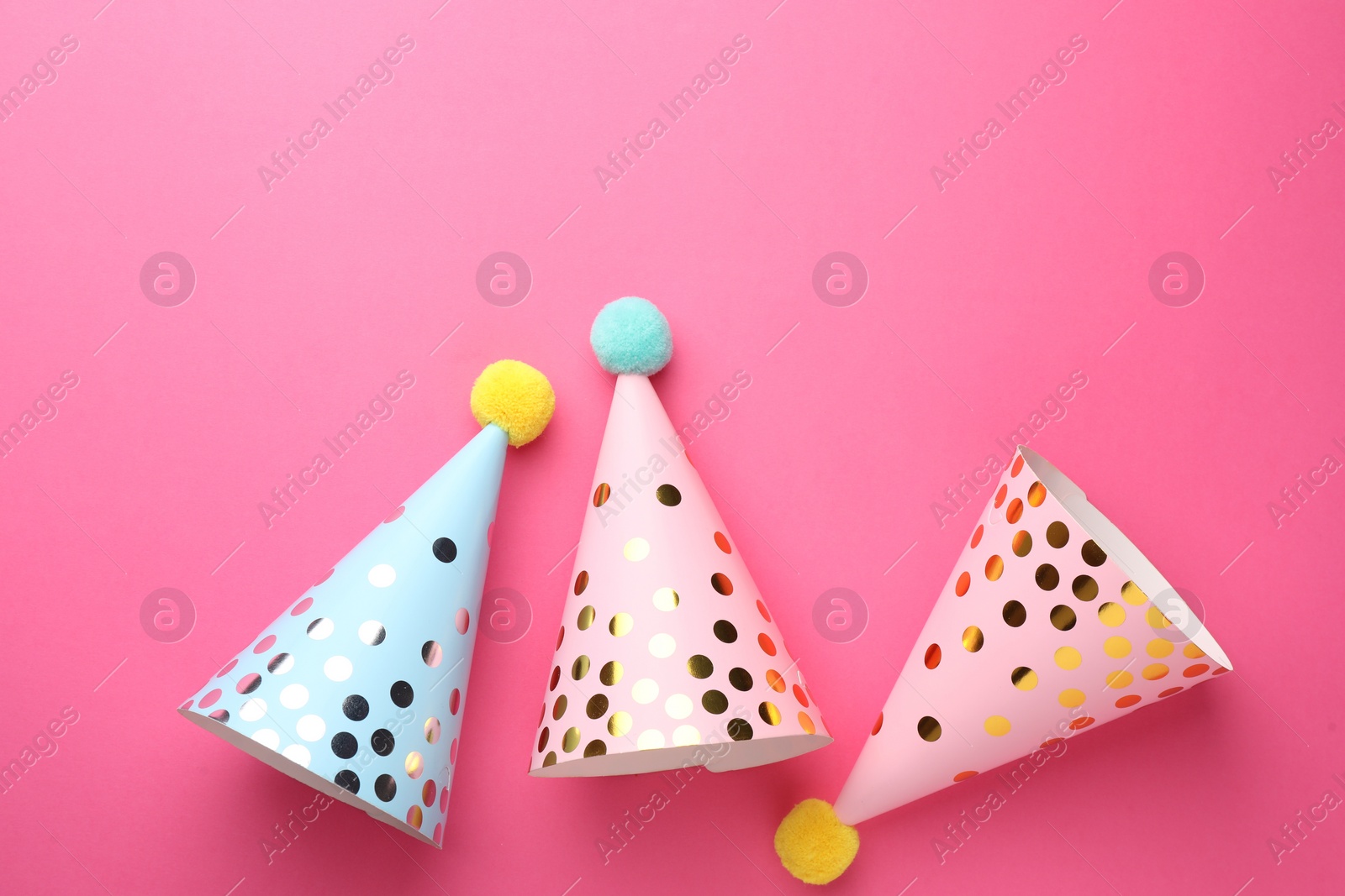 Photo of Beautiful party hats on pink background, top view. Space for text