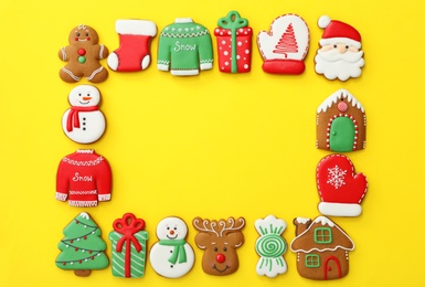 Photo of Frame made with different Christmas gingerbread cookies on yellow background, flat lay. Space for text