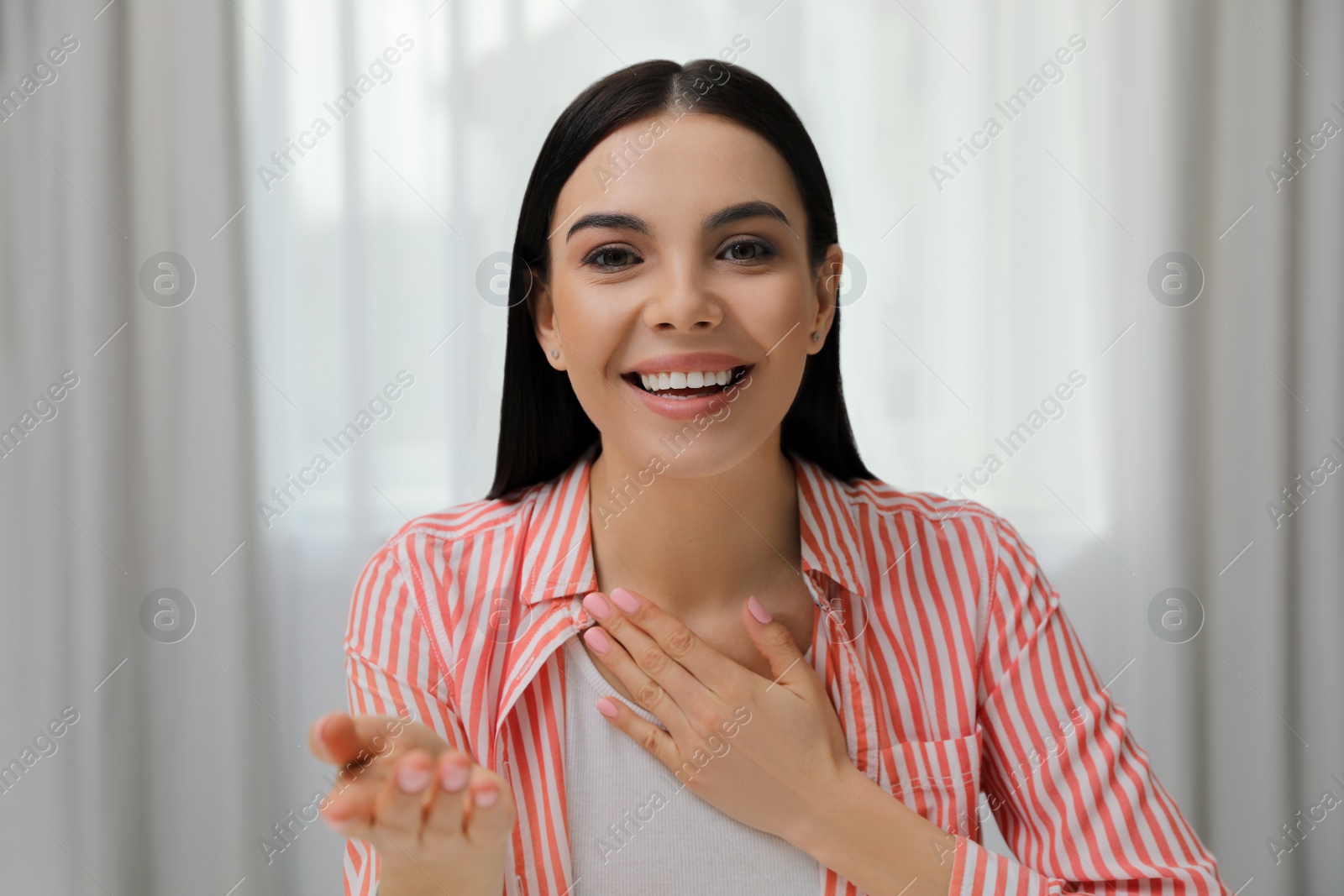 Photo of Beautiful young woman conducting webinar in room, camera view