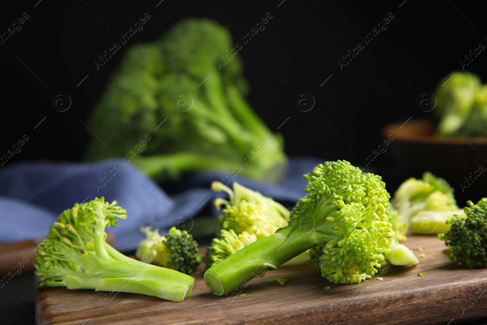 Photo of Raw green broccoli on wooden cutting board