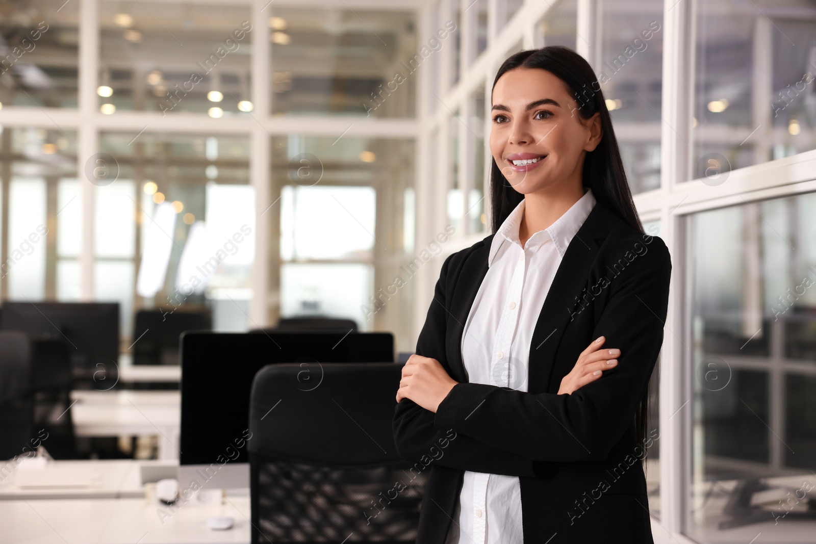 Photo of Happy woman with crossed arms in office, space for text. Lawyer, businesswoman, accountant or manager