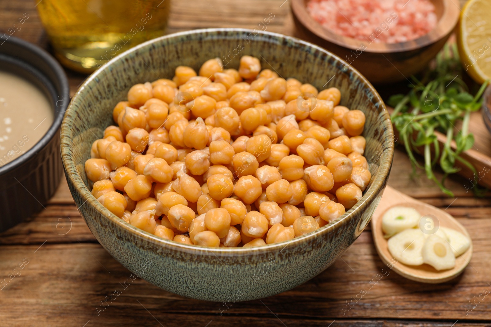 Photo of Delicious chickpeas on wooden table, closeup. Hummus ingredient