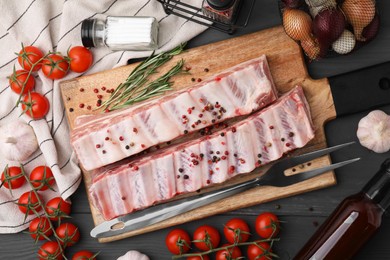 Photo of Flat lay composition with raw pork ribs and spices on grey wooden table