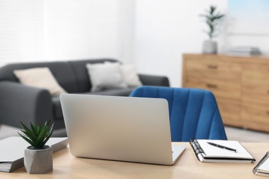 Photo of Home workspace. Laptop and stationery on wooden desk indoors