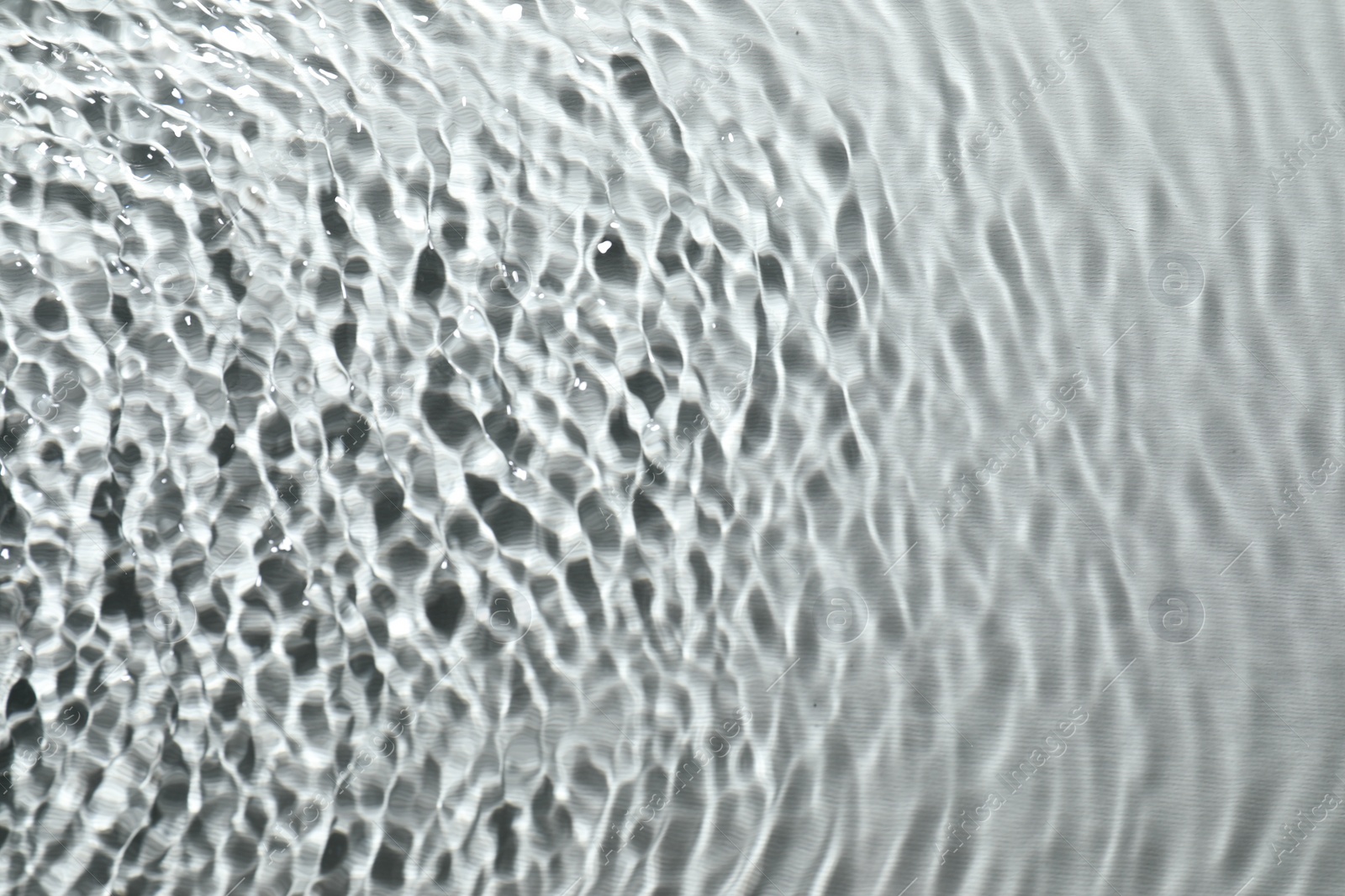 Photo of Rippled surface of clear water on light grey background, top view