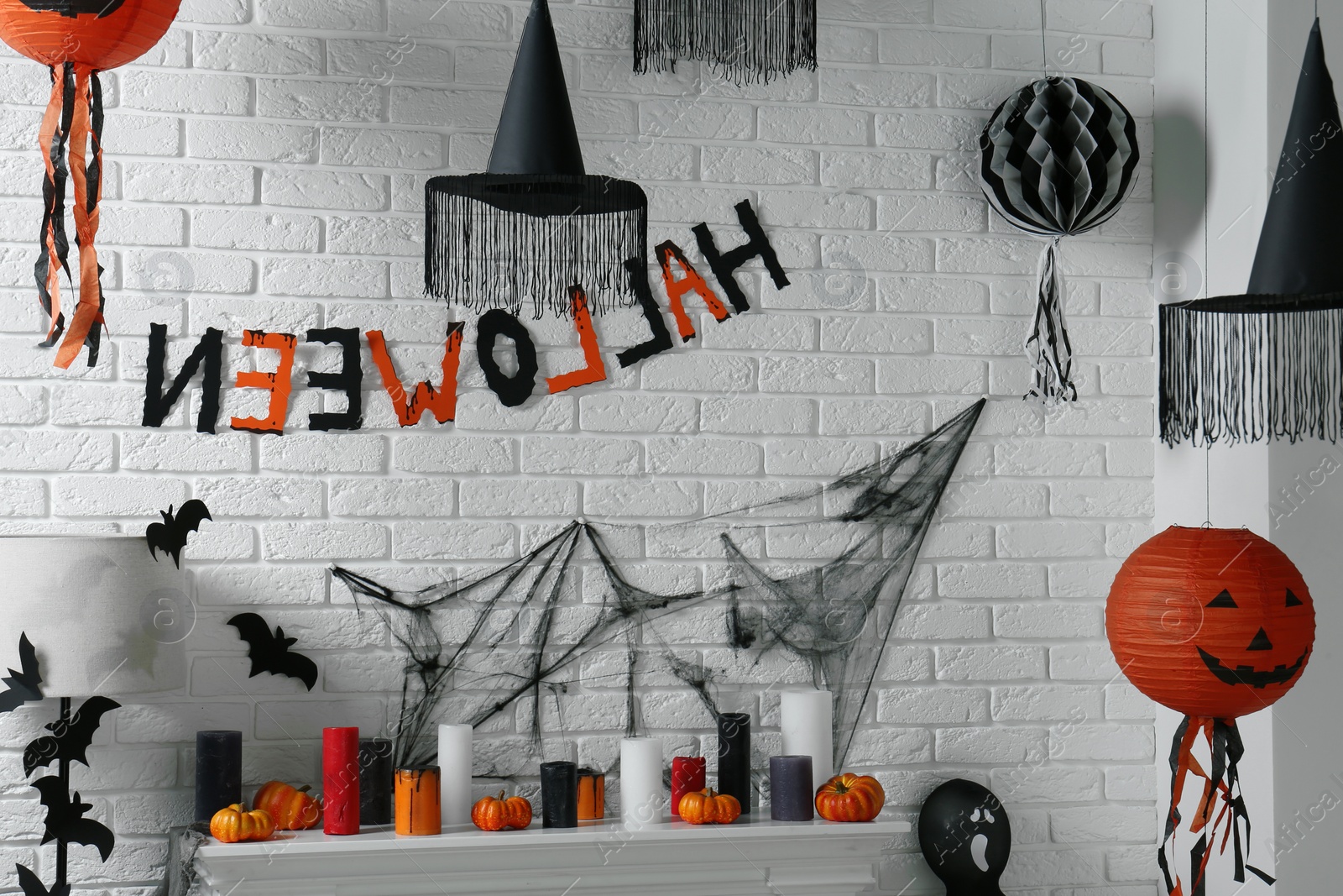 Photo of Fireplace with different Halloween decor indoors. Festive interior