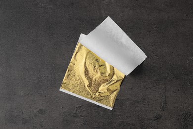 Photo of Edible gold leaf sheet on textured table, top view