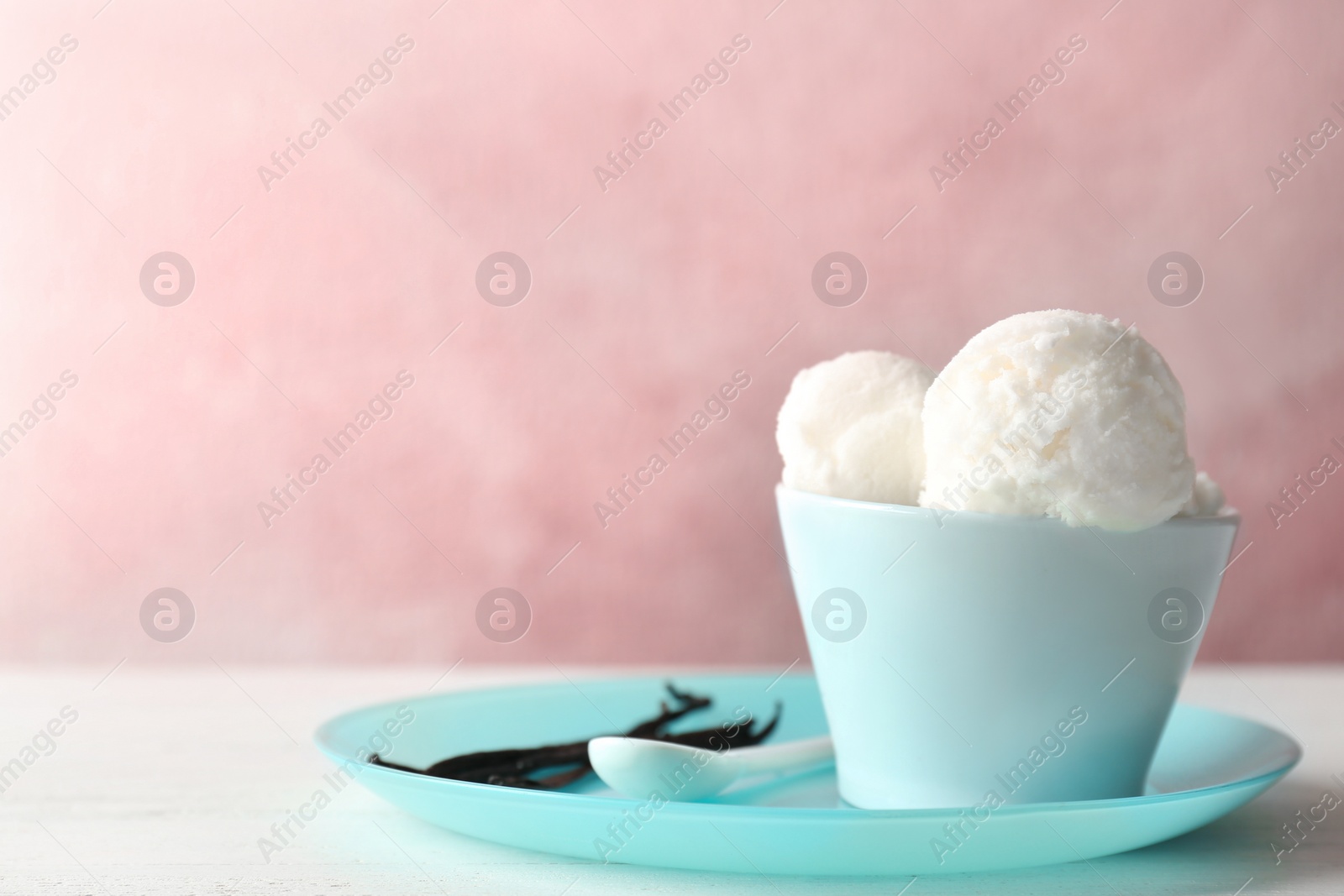 Photo of Bowl with tasty vanilla ice cream on table