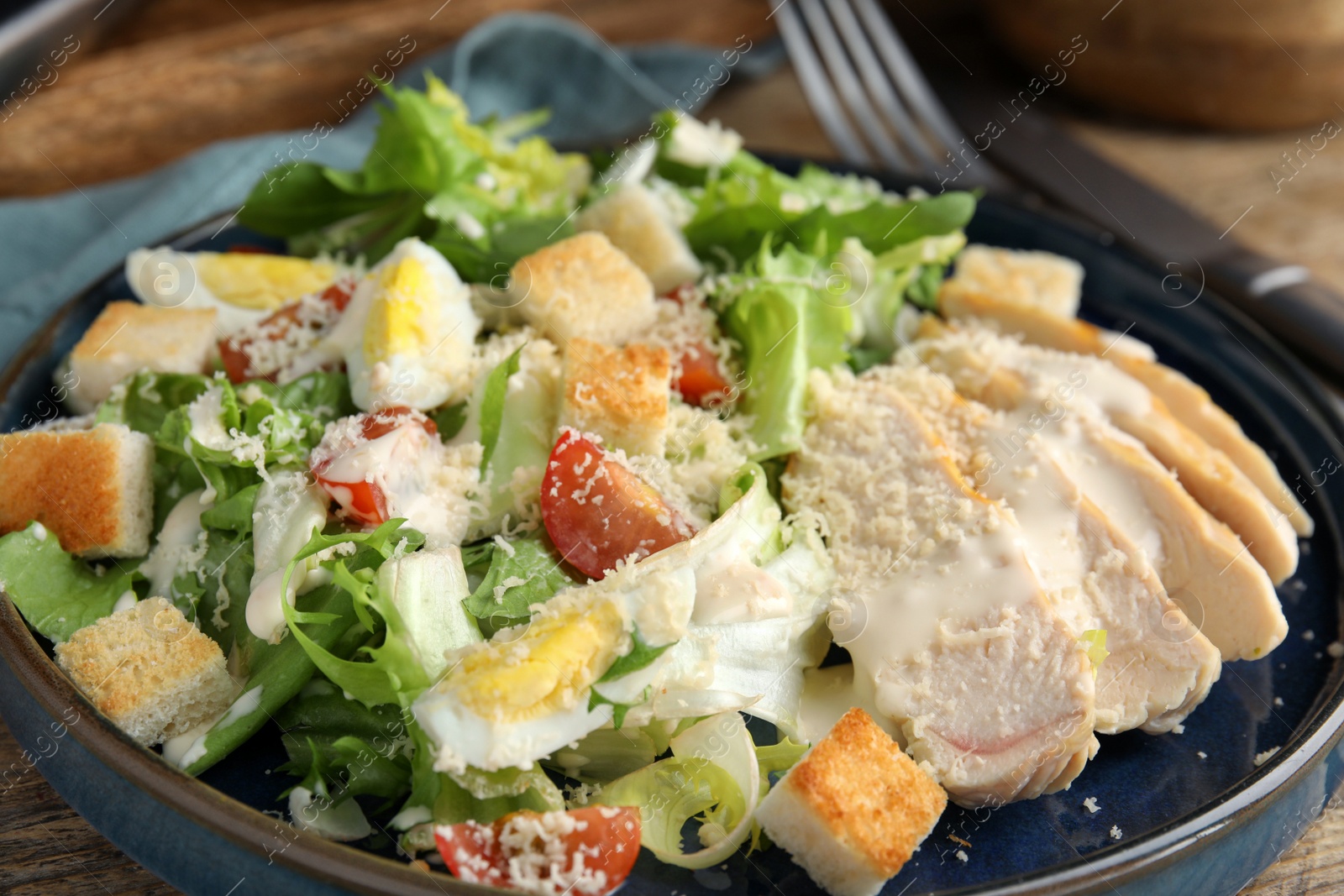 Photo of Delicious Caesar salad in bowl, closeup view