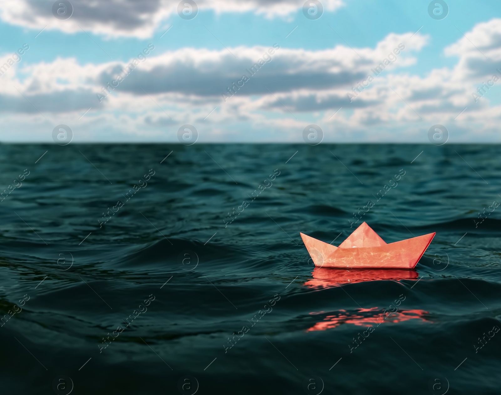 Image of White paper boat floating on sea. Space for text 