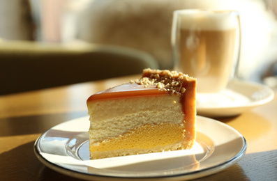 Piece of delicious cheesecake on table in cafe, closeup