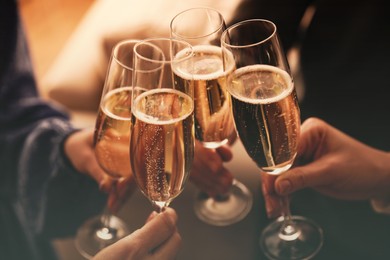 Image of People clinking glasses with sparkling wine indoors , closeup