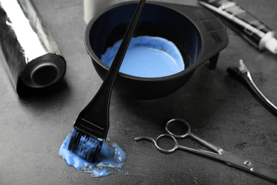 Photo of Professional tools for hair dyeing on grey stone background