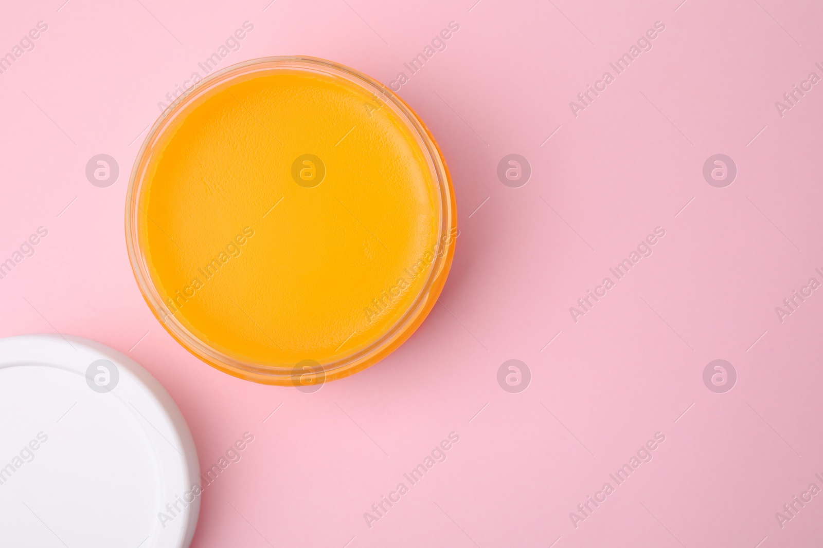 Photo of Open jar with petrolatum on pink background, top view. Space for text