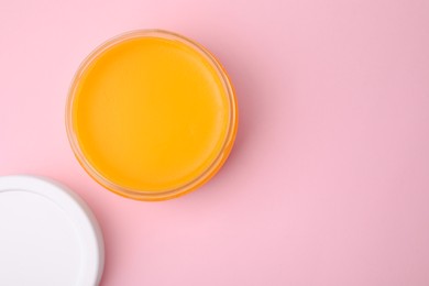 Open jar with petrolatum on pink background, top view. Space for text