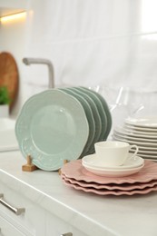 Clean plates and cup on white marble countertop in kitchen