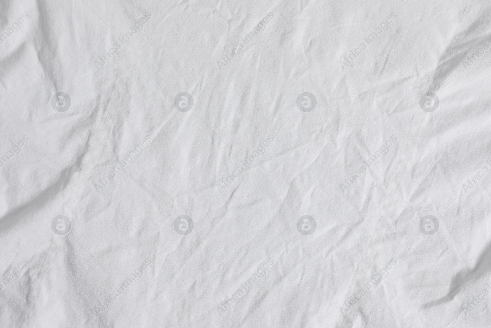 Photo of Crumpled white fabric as background, top view