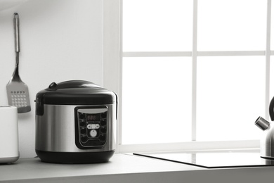 Photo of Modern electric multi cooker on kitchen countertop. Space for text