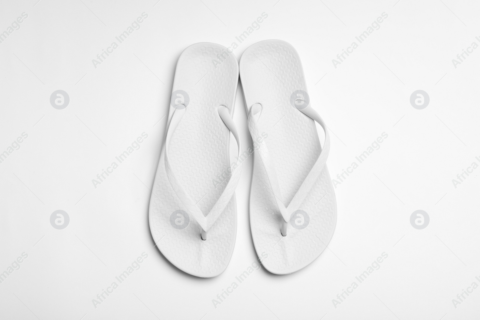 Photo of Pair of flip flops on white background, top view. Beach accessories