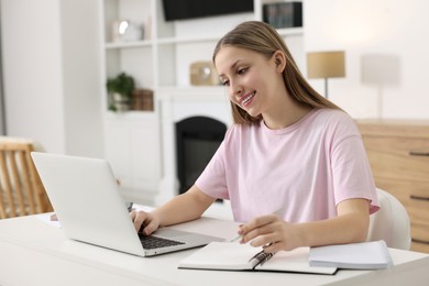 Photo of Online learning. Teenage girl typing on laptop at table