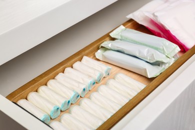 Storage of different feminine products in white drawer, closeup