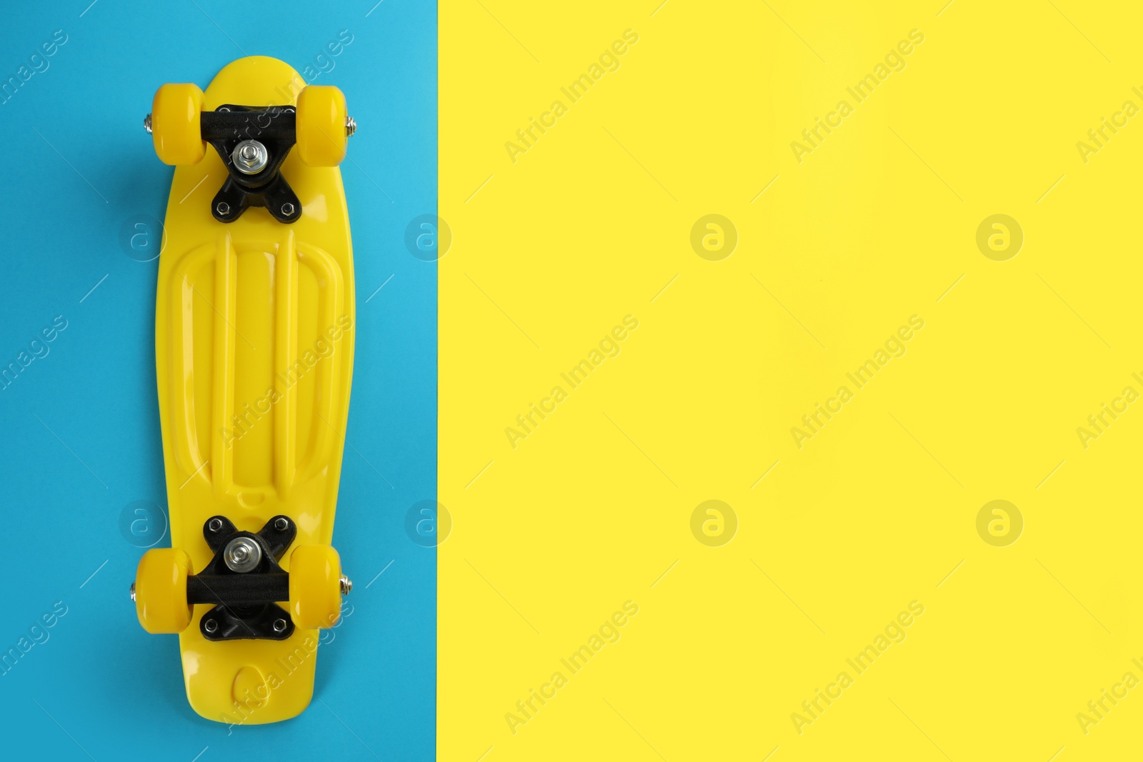 Photo of Yellow skateboard on color background, top view. Space for text