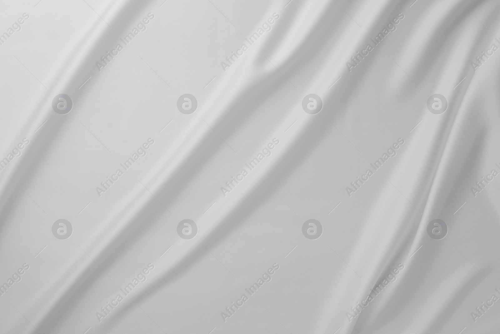 Photo of Texture of crumpled white silk fabric as background, top view