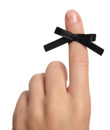 Photo of Woman showing index finger with tied black bow as reminder on white background, closeup