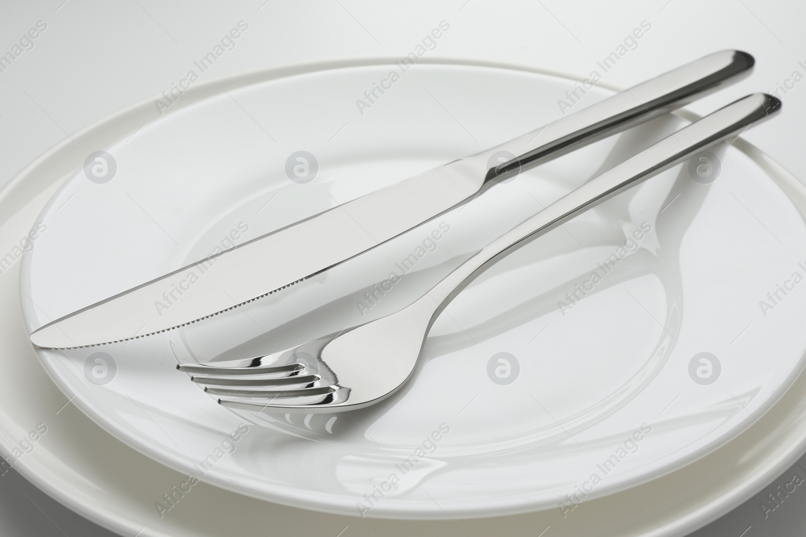 Photo of Clean plates, fork and knife, closeup view