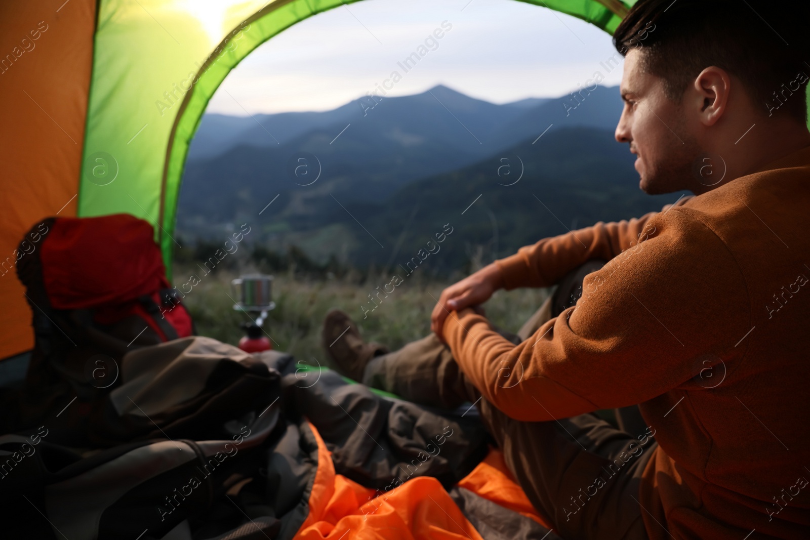 Photo of Man inside of camping tent in mountains