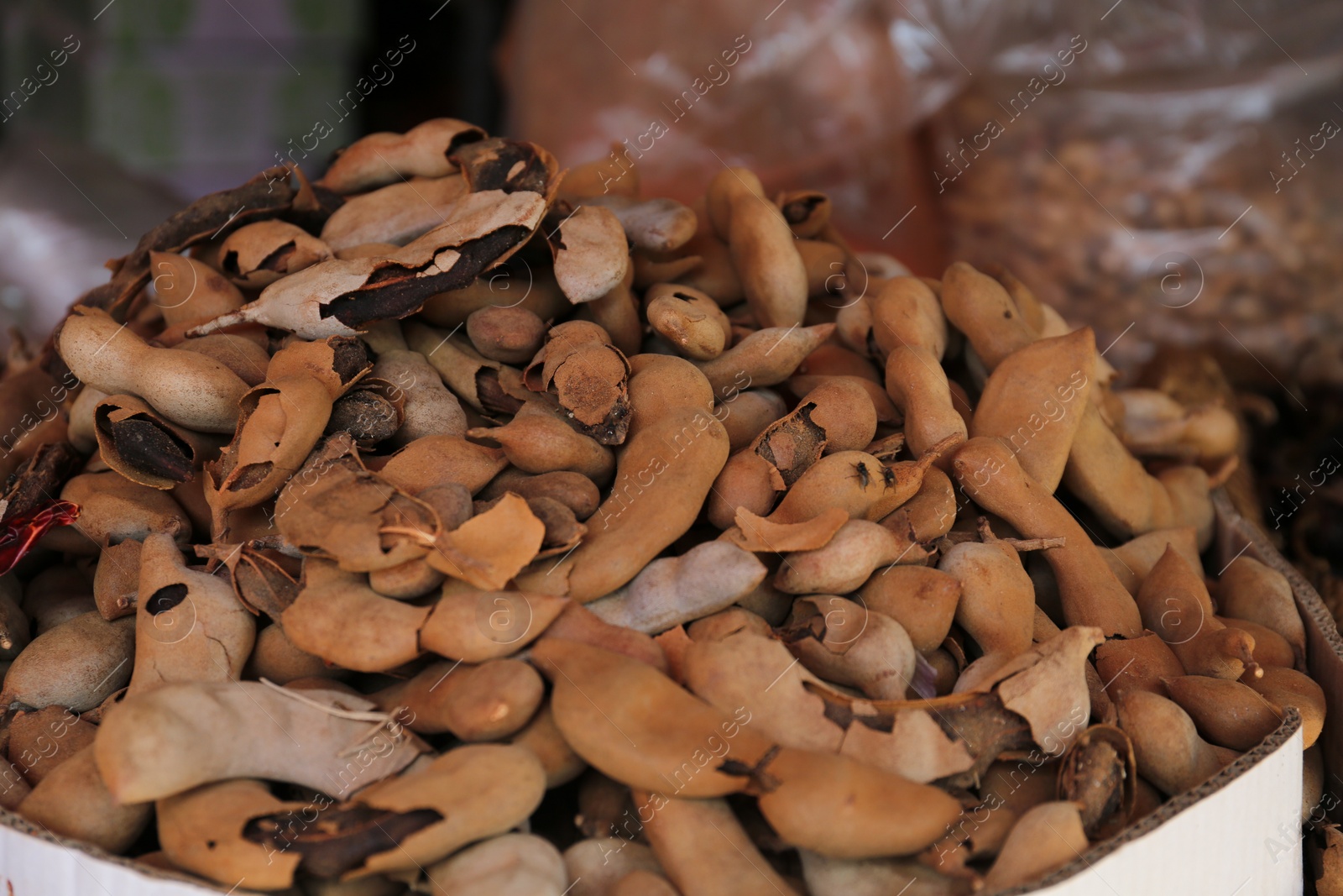 Photo of Heap of delicious tamarinds on counter at market, closeup