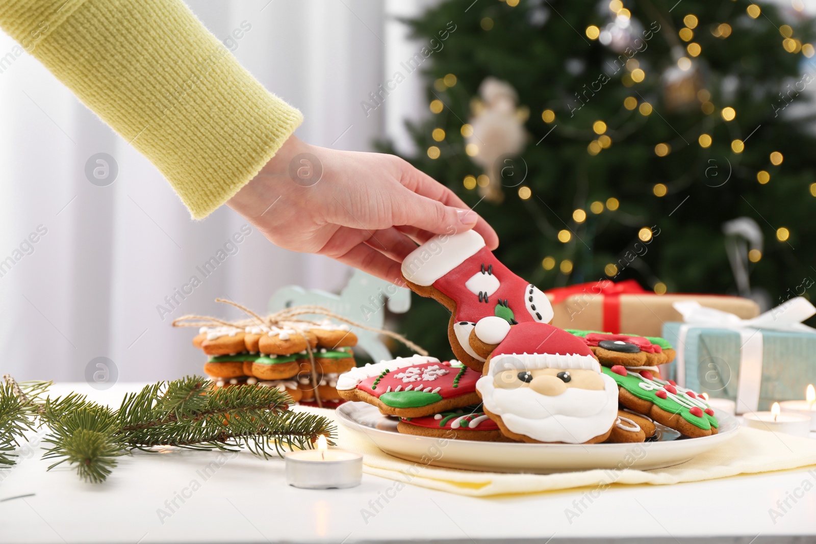 Photo of Woman with decorated Christmas cookie at table, closeup