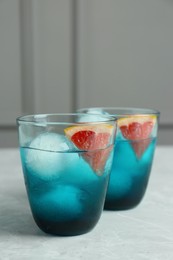 Photo of Delicious cocktails with grapefruit and ice balls on grey table, space for text