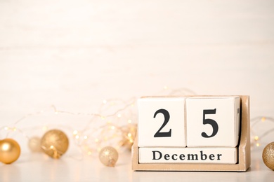 Photo of Block calendar and festive garland on table. Christmas countdown