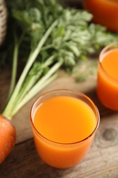 Photo of Freshly made carrot juice on wooden table